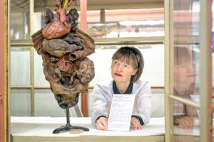 Kuratorin Claudia Steinicke mit einem über 250 Jahre alten Trockenpräparat eines „situs inversus“ aus der Sammlung von Meckel d. Ä. (Foto UMH